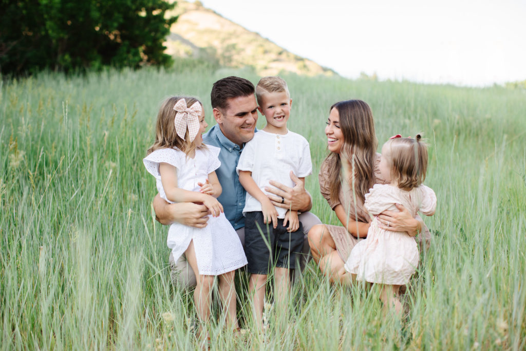 Family Sitting in a field. Utah Photographer Mary Horne Nelson discusses Mini Sessions vs Full Sessions.