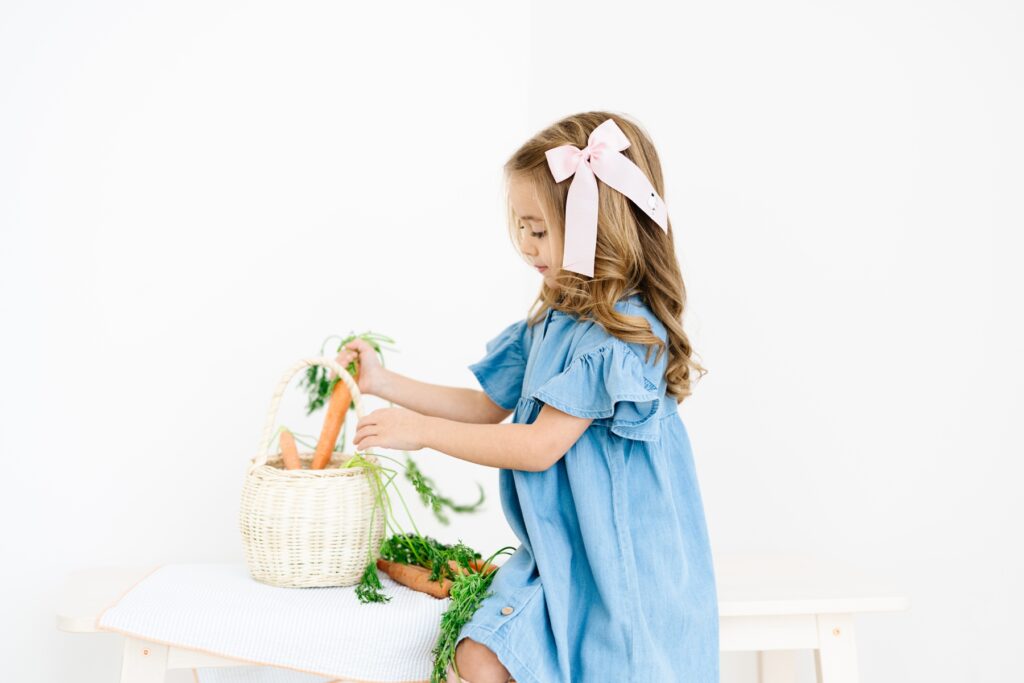 Commerical Photography for Children's Brands spring campaign for Winn and William. Girl placing carrots into a basket