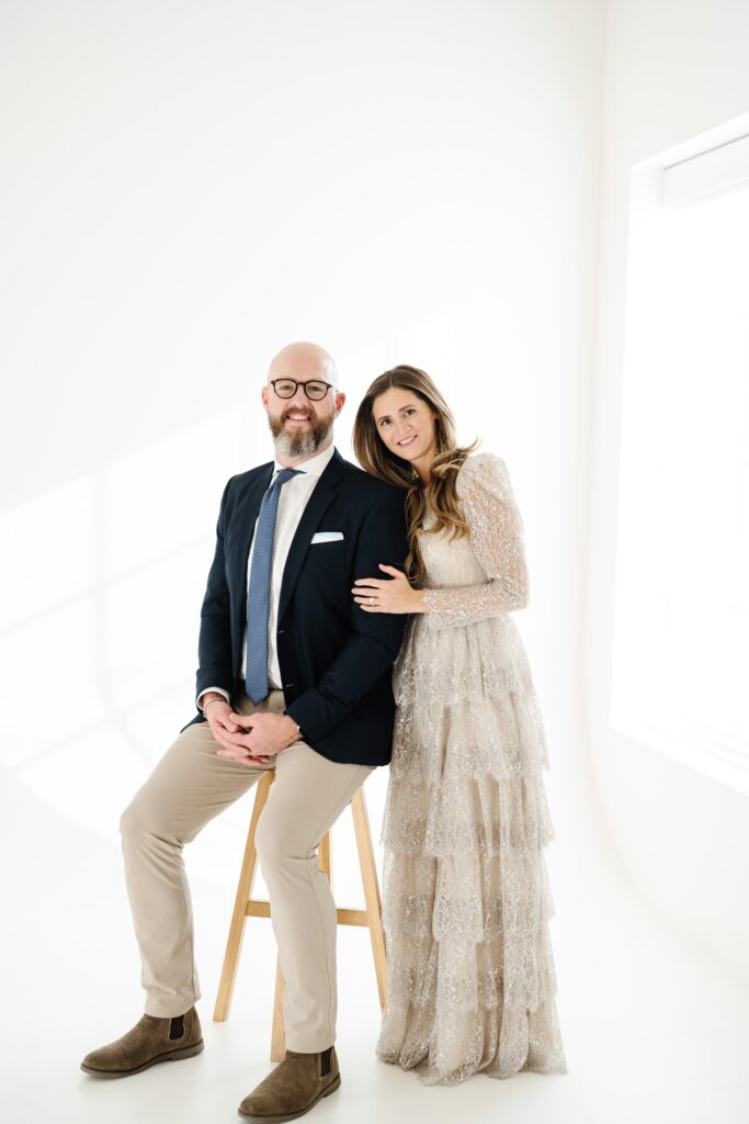 Parents posing together in a white studio