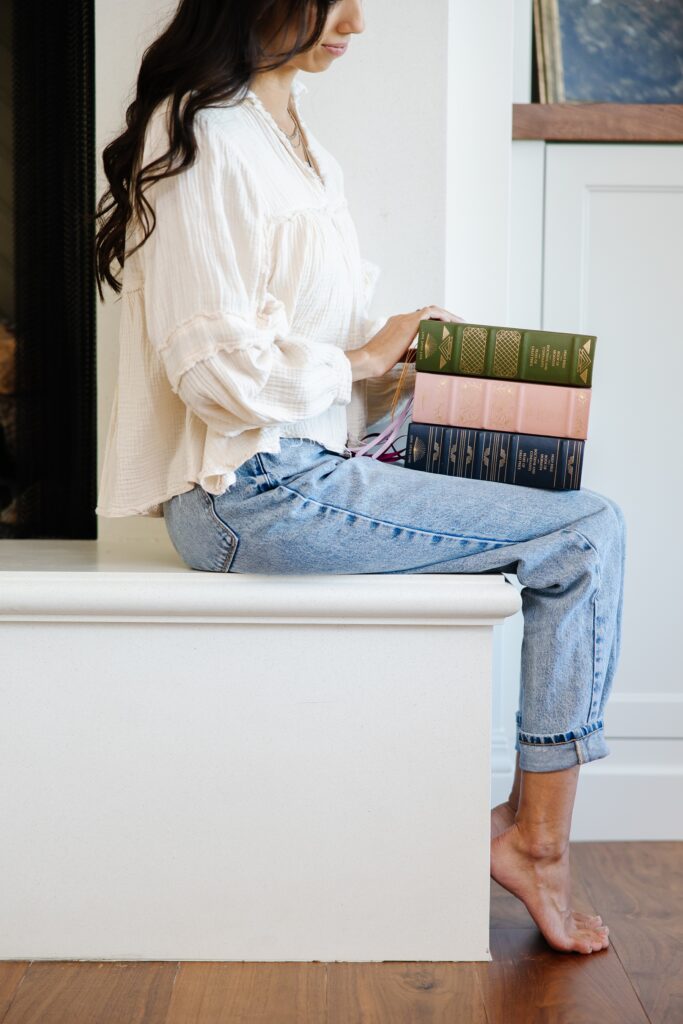 Utah Commercial Photography for Line Upon Line Stack of books of woman's lap